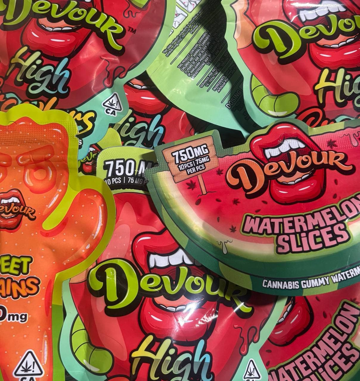 Colorful Devour cannabis gummy packages featuring mouth graphics, watermelon slices, and 750mg dosage labels.