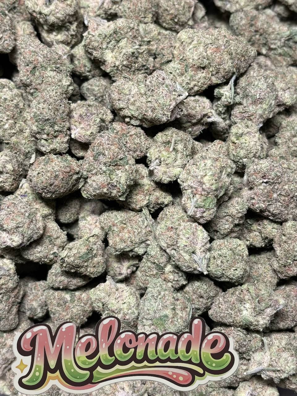 Dense, frosty cannabis buds with purple hues and a stylized "Melonade" logo at the bottom.