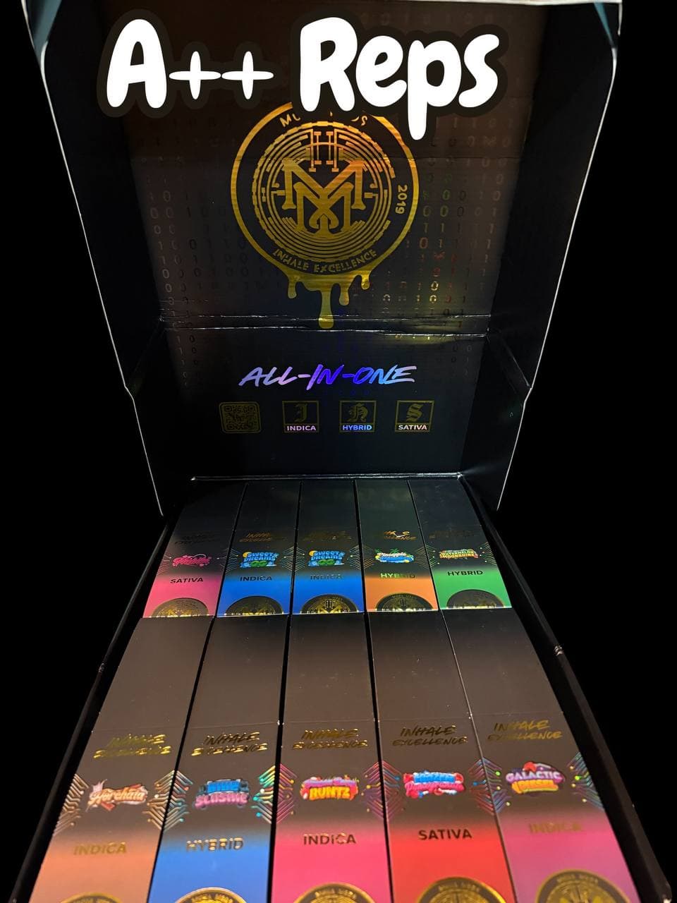 Black display box showcasing rows of colorful Muha Meds all-in-one cannabis vape cartridges and packaging.